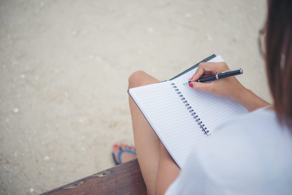 Close up of woman hand writing on notepad.